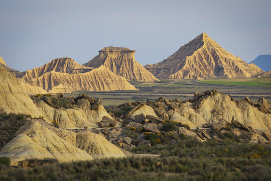 View of the unique eroded rock formations and arid badlands of Bardenas Reales under a clear sky in Navarre, Spain.
