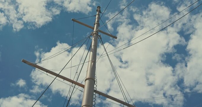 Sailboat Mast Against Blue Sky with Clouds