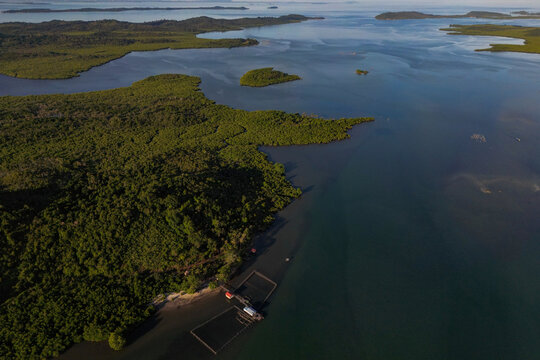 Aerial view of Galang Baru featuring lush green hills, excavated land plots, and a scenic coastline with scattered islands Galang, Riau Islands, Indonesia.