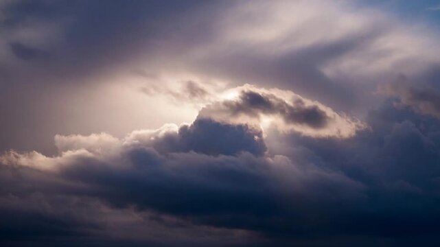 Storm clouds gather in the darkening sky as a sliver of sunlight breaks through the thick, dramatic overcast atmosphere.