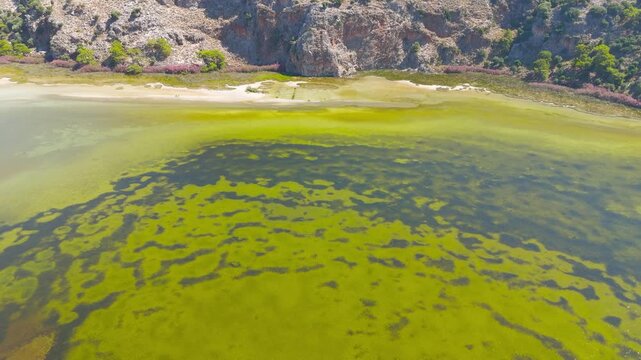Dalyan, Turkey. Iztuzu Beach, a narrow sand spit where the Dalyan River meets the Mediterranean Sea, aerial drone view over turquoise shallows and golden shoreline backed by arid green mountains. Aer
