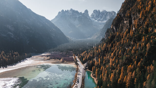 Aerial view of Durrensee lake with turquoise water surrounded by autumn forests and the jagged peaks of the Dolomites in Toblach, Trentino-Alto Adige S, Italy.