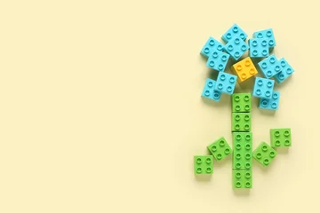 Fotobehang Lego Flower made of colorful plastic building blocks on beige background  © Pixel-Shot