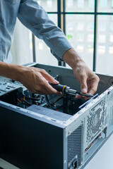 Fototapeta premium Asian IT engineer using screwdriver fix pc case