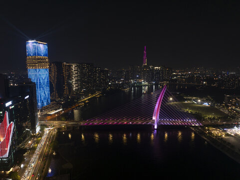Aerial view of Thu Thiem 2 Bridge illuminated with pink lights and modern skyscrapers with LED displays at night Ho Chi Minh City, Ho Chi Minh, Vietnam.