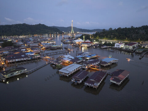 Aerial view of Kampong Ayer water village with houses on stilts and the illuminated RIPAS Bridge at twilight in Bandar Seri Begawan, Brunei-Muara District, Brunei.