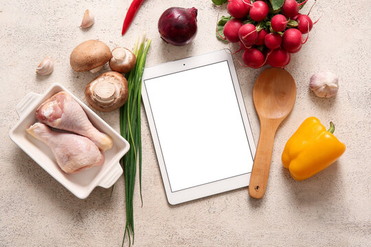 Digital recipe book with kitchen utensils and ingredients on white grunge background