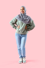 Fototapeta premium Young Muslim woman on pink background