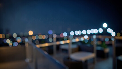 Fototapeta premium Stone and metal terrace foreground with luminous circular bokeh lights at night