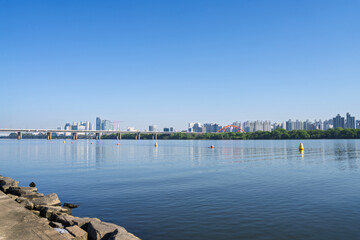 Fototapeta premium Seoul Skyline and Cityscape with a Bridge along the Han River and Blue Sky
