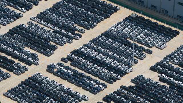 Aerial view of hundreds of new electric vehicles parked in neat rows at the BYD Thailand Rayong Office Building in Phananikhom, Rayong, Thailand.