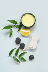 Obraz premium Bowl of lemon body scrub with massage brush and spa stones on grey background