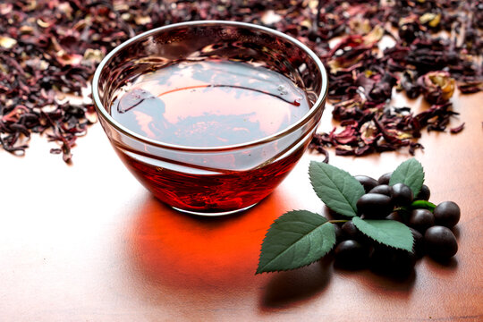 Still life cup of black tea with mint leaves on dried karkade tea contrast background