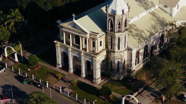 Historic stone facade of Dauis Church in sunny Bohol Philippines, drone telephoto orbit