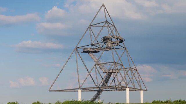The tetraeder observation tower in bottrop, germany, standing against a partly cloudy blue sky