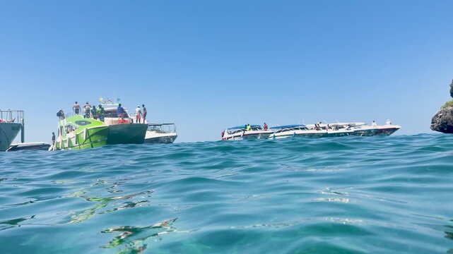 Tourists Swimming Near Speedboats in the Clear Waters of Phi Phi Islands