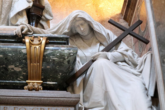 Roma, Italia - Dettaglio della statua allegorica in marmo bianco raffigurante la Fede dolente con una croce lignea, parte del monumento funebre di Papa Leone XIII nella Basilica di San Giovanni in Lat