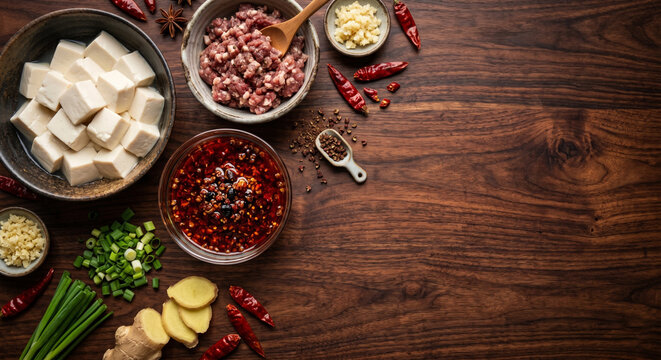 Flat lay of Mapo Tofu ingredients on dark rosewood, copy space