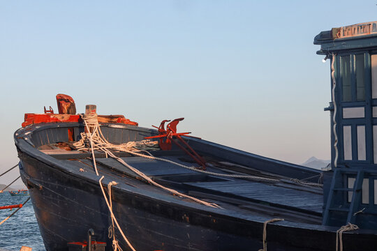Traditional Wooden Boat Moored at Sea During Golden Hour