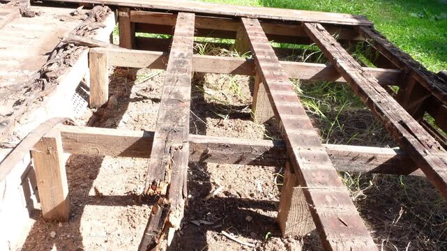 Rotted wood deck boards decayed timber caused by fungi thriving in damp conditions, represent a significant structural risk, house renovations project.