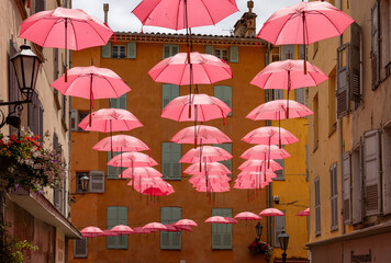 Streets of Grasse, a city known for its perfumery, decorated with pink umbrellas on the occasion of the annual international exhibition of roses - Expo Rose. © wjarek