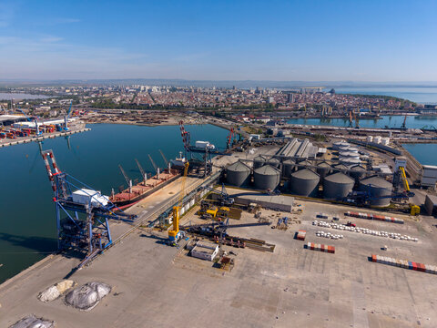 Port industry scene with cargo ships and storage facilities in daytime