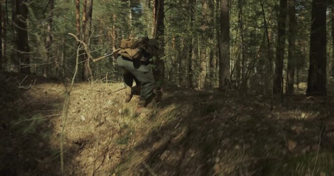 Reenactor Dressed As German Infantry Soldier Takes Cover In Pit. Soldier With