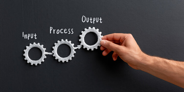Businessman hand placing gear for input process output workflow management solution showing focused confident business strategy development