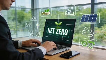 Fototapeta premium Businessman working on laptop with net zero carbon emissions concept, digital interface showing green energy icons like solar panels and recycling symbols for sustainable