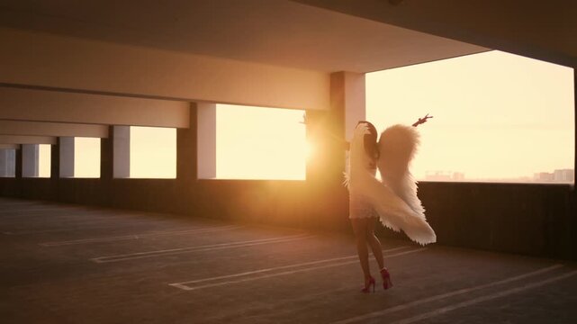 Photographer captures a fashion model with angel wings during a cinematic golden hour rooftop photoshoot with warm sunlight and dreamy atmosphere.