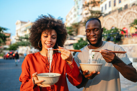 Young travelers relaxing with authentic street food, discovering new cultures and local cuisine