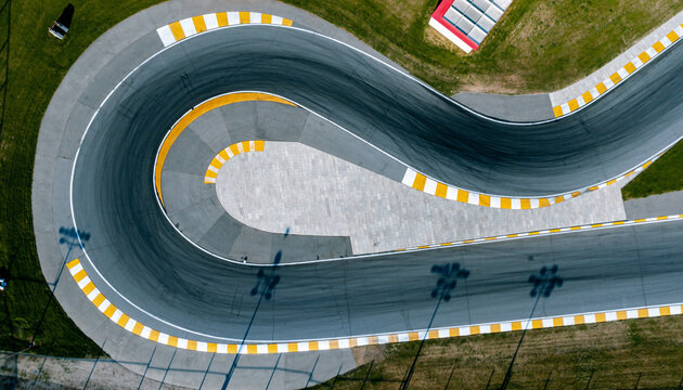 Aerial view of a winding race track with yellow and white markings.