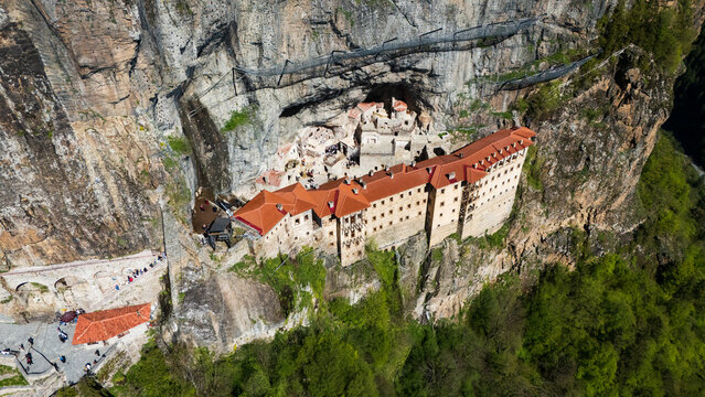 Breathtaking top-down drone perspective of the historic Greek Orthodox Sumela Monastery nestled among dense green pine woods in Trabzon, Turkey