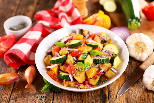 Homemade french ratatouille stew with zucchini, eggplant and herbes de provence on rustic wood