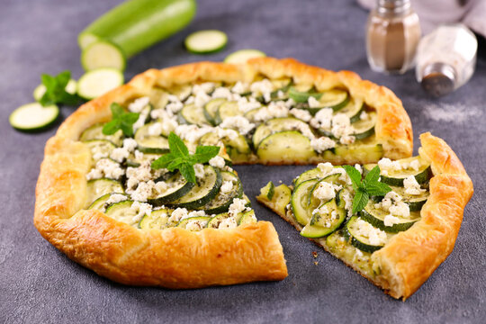 zucchini goat cheese galette with fresh mint slice cut on rustic background