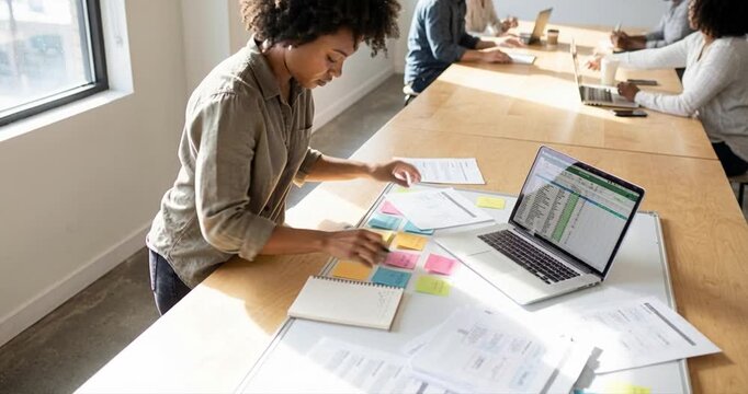 Woman working at desk with laptop and papers