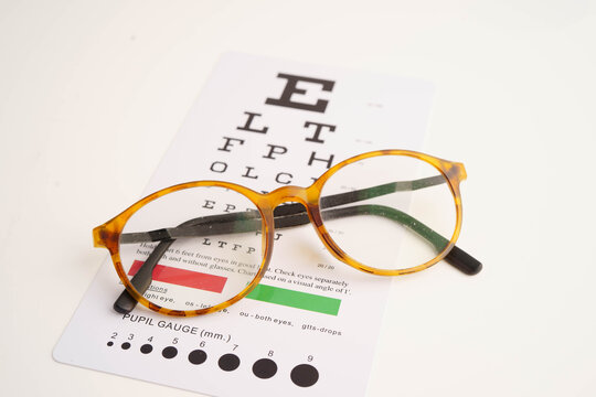 Glasses on eye testing exam chart to check eyesight accuracy of reading.