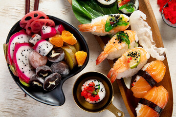 A table with Asian food, sushi, rolls, desserts. © bit24