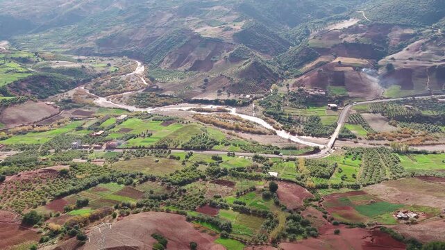 Cinematic aerial drone panorama of the Oum Er-Rbia river valley surrounded by colorful farmland and mountain landscapes in the Middle Atlas Morocco ideal for travel nature and documentary projects