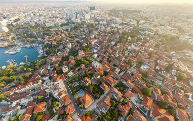 Fototapeta premium Antalya, Turkey. Overhead aerial shot demonstrating the direct contrast between the dense, historic Kaleici Old Town and the adjacent modern urban development under morning sun. Aerial view.