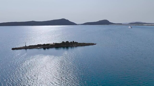 Aerial Drone View of Rocky Islet with Navigation Beacon, Luxury Yacht and Sunlit Blue Water in Navarino Bay near Gialova, Peloponnese, Greece