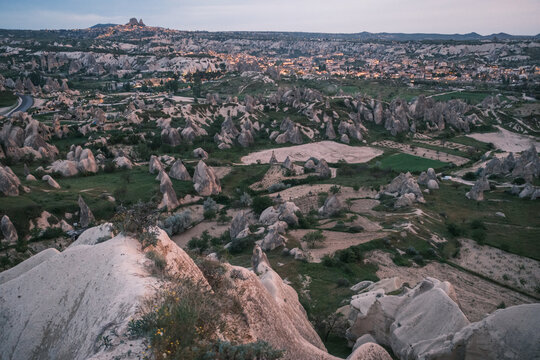 Panoramic view of ancient stone houses and rock-cut cave dwellings in the historic Cavusin village, Cappadocia, Turkey. Unique volcanic tuff formations in a lush Anatolian valley