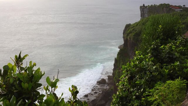 Pura Luhur Uluwatu temple at golden hour in Bali, Indonesia with turquoise ocean and dramatic cliffs