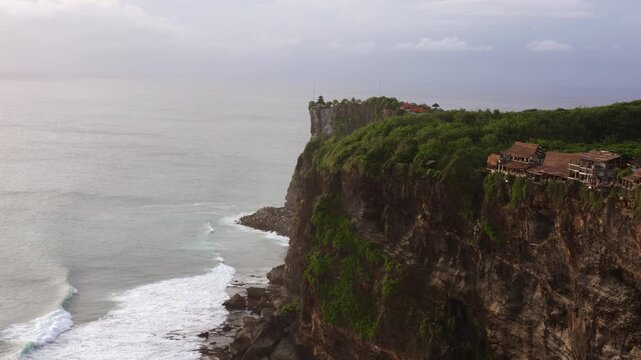 Pura Luhur Uluwatu temple at golden hour in Bali, Indonesia with turquoise ocean and dramatic cliffs