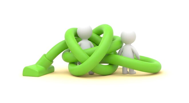 Two white figures stuck in a tangled green hose