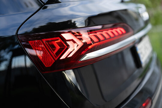 Rear LED lights closeup of electric SUV, stylish exterior design of car. Headlight, taillight, car, brake, indicator, led, light. Close up detail on one of the LED red taillight modern crossover car