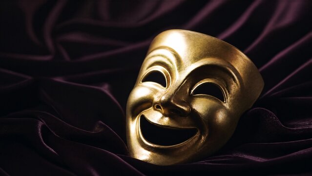 Theatrical comedy mask with wide grin on dark velvet cloth, soft spotlight.