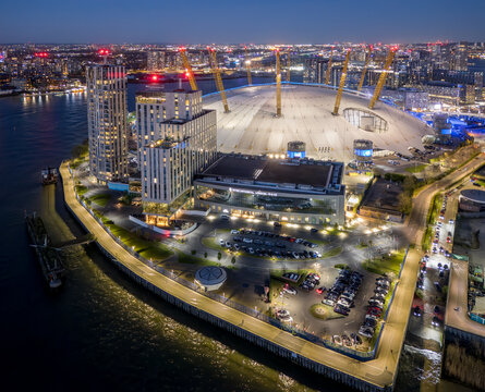 London, The O2 Arena aerial view at night in London, England, illuminated entertainment venue beside the River Thames in Greenwich.
