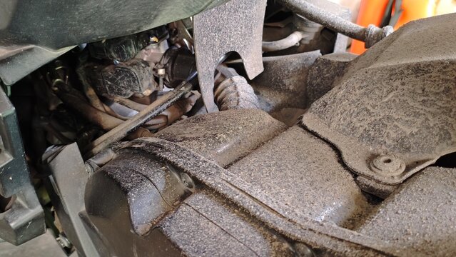 Motorcycle engine compartment closeup with dusty mechanical parts and industrial details. Automotive background suitable for repair, engineering, and transportation concepts.