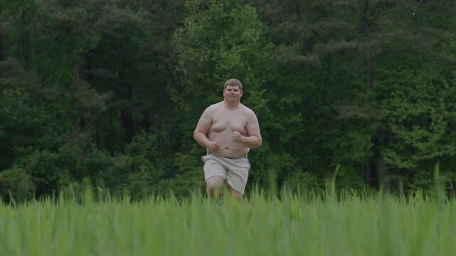 Overweight man begins exercise. Outdoor overweight workout effort. Jogging overweight body concept. Overweight runner seeks weight loss.